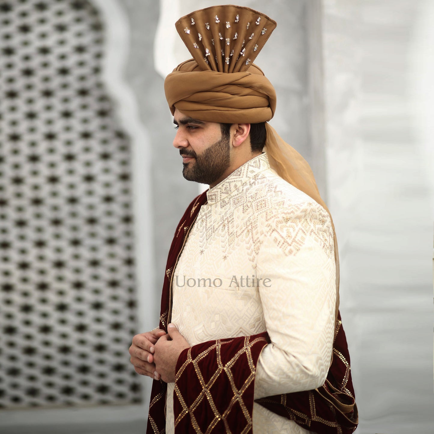 
                  
                    Luxurious Beige Sherwani Set for Groom with Embellished Turban and Maroon Shawl
                  
                