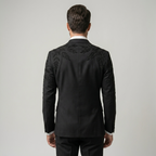 Man wearing a black suit with intricate embroidery on a plain background | Bespoke Black Double Breasted Tuxedo Jacket with Leaf Embroidery