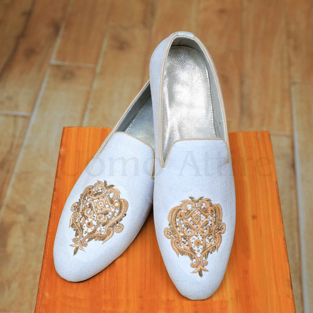 White fabric shoes with golden embellishments